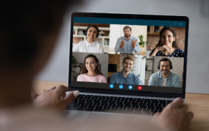 Over The Shoulder View Of A Woman On Video Call With Six People For Work
