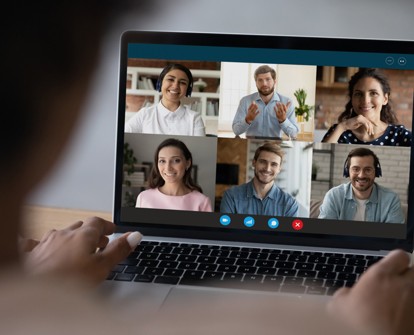 Over The Shoulder View Of A Woman On Video Call With Six People For Work